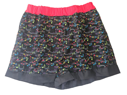 Black women’s loungewear boxers in ‘Do Re Mi Lounge ’ print, featuring colorful musical notes on a black background, red elastic leg bands, and deep pockets — handmade and comfy for music lovers.