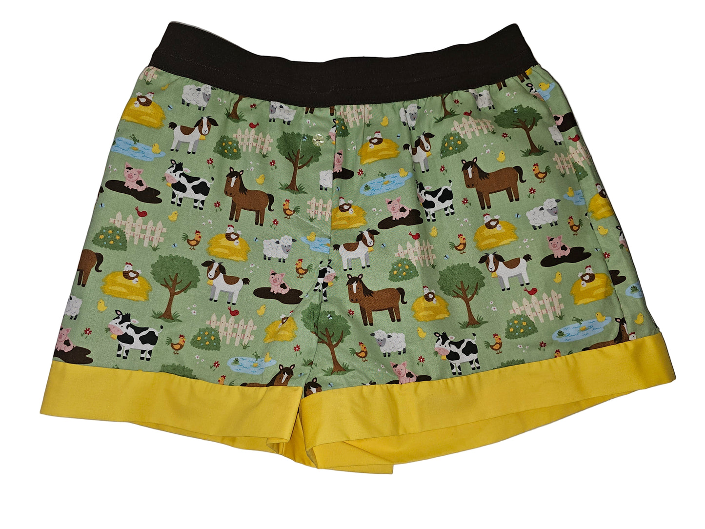Women's Loungewear boxer in 'Lazy Pasture Paradise' farm print, featuring playful farm animals on a soft green background, two-inch yellow elastic waistband, brown leg bands, and deep side pockets — handmade, breathable, and comfy.”