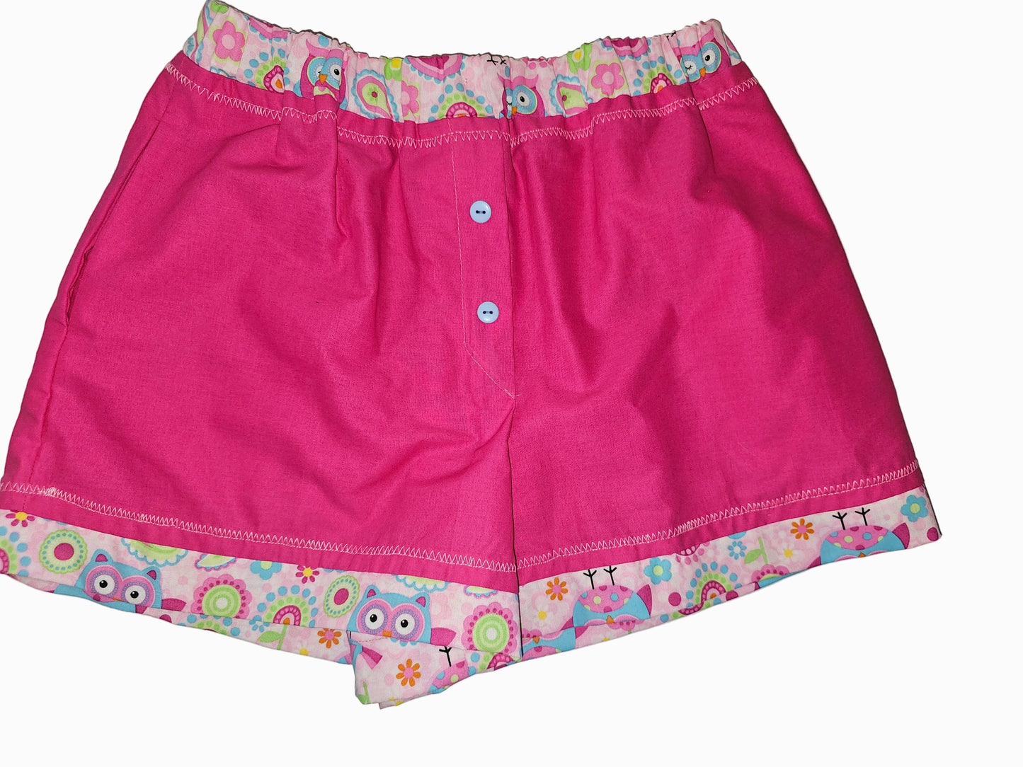 Women's soft cotton lounge boxers with a playful design of a cartoon owl  with pink, light blue, light green, purple  and hot pink, with circle designs in the waist and leg bands, light blue detail buttons, with pink being the main design color of the boxer -size small